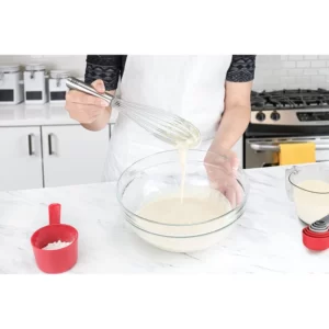 A woman is mixing Stainless Steel Egg Dough Mixing Mixer Tool in a bowl with a whisk.