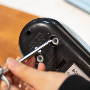 A person is using a Scarlett Hand Mixer Egg Beater 7 Speed Kettle to open a microwave.