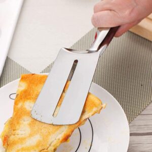 A person cutting up a piece of pizza on a plate.