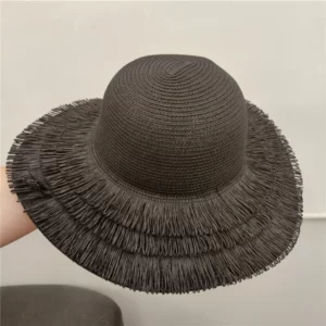 A person holding a black Straw Hats with fringe Edge.