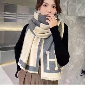 A woman wearing a High Quality Soft Fashion Scarf with the letter h on it.