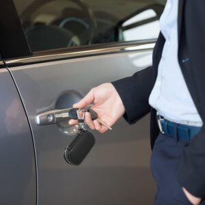 A man in a suit is opening the door of a Keychain with Carabiner Hook.