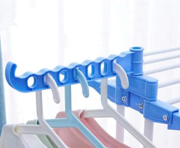 A blue and white Foldable Adjustable Clothes Drying Rack with clothes hanging on it.