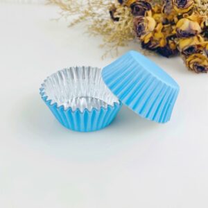 A set of Muffin Cupcake Silicone Baking Cups With Tray on a table next to flowers.