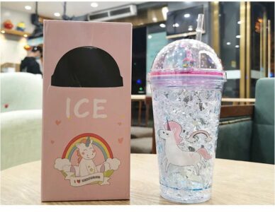 A 3D Rainbow Glitter Stars Tumbler with a unicorn on it next to a box.