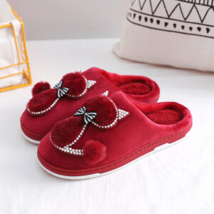 A pair of Women's Winter Thickened Anti Slip Slippers with bows on them.