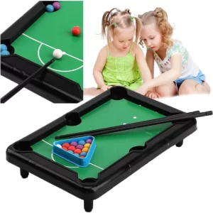 A little girl playing billiards with a Kids Travel Mini Pool Table Set.