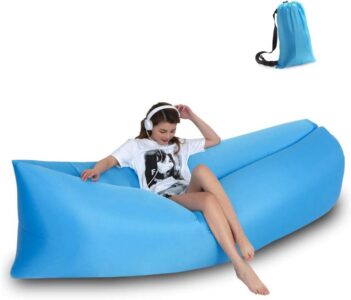 A girl is sitting on an Outdoor Inflatable Recliner.