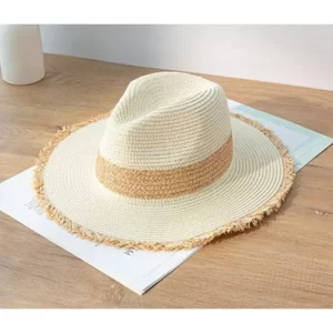 A Fashion Straw Panama Sun Hats For Women with tassels on top of a wooden table.