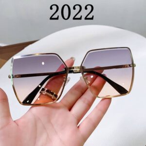 A hand holding a pair of sunglasses with the word 2020 on it.