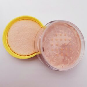 A jar with a yellow lid and Iman Of Noble Banana Setting Powder in it.