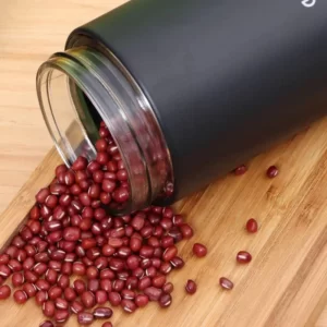 A Multifunction Creative Food 3 Glass Jars full of pomegranate seeds on a wooden cutting board.