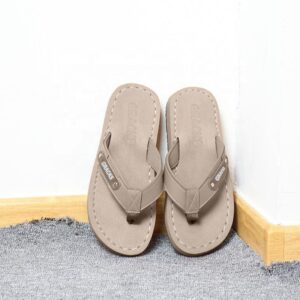 A pair of brown flip flops sitting on the floor.