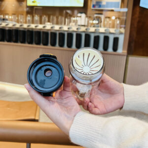 A person holding an 800Ml Bpa Free Plastic Sport Water Bottle with a lid.