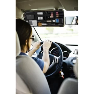 A woman sitting in the driver's seat of a Grid-It! Vehicle Storage Plate Accessory Organizer.
