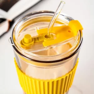 A yellow Water Cup With Lid And With Silica Cover and a book.