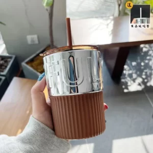 A person holding an Electroplating Coffee Cup With Lid Straw.