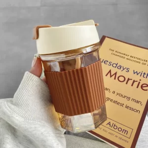 A person holding a book and an Anti Scale Silicone Cover Coffee Cup With Straw.
