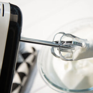 A person is mixing whipped cream with a Scarlett Hand Mixer Egg Beater 7 Speed Kettle.